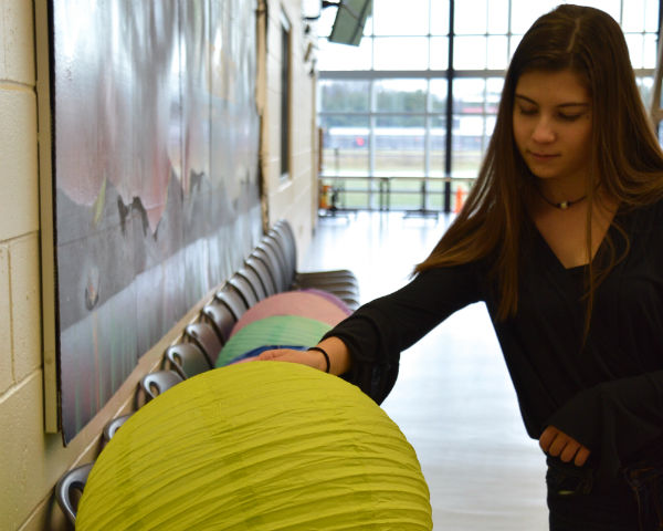 Sophomore Kathryn Jemas of Long Branch stays after to set up decorations. The Class of 2019 used light bulbs and paper lanterns to convey their Northern Lights theme. 
