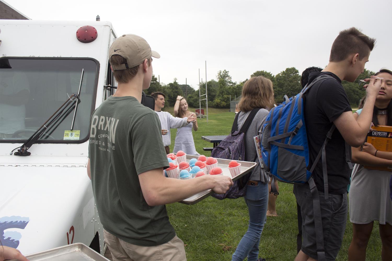 SGA council member and senior Jonathan Slovak of Spring Lake Heights hands out Italian ice to students.