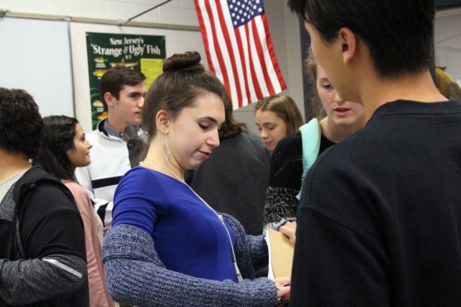 At the Thursday Skills USA meeting, senior Nora Thomson of Middletown signs in while other members talk before the meeting begins. This weeks meeting was centered around the Homecoming dance and encouraged members to sign up for committees.