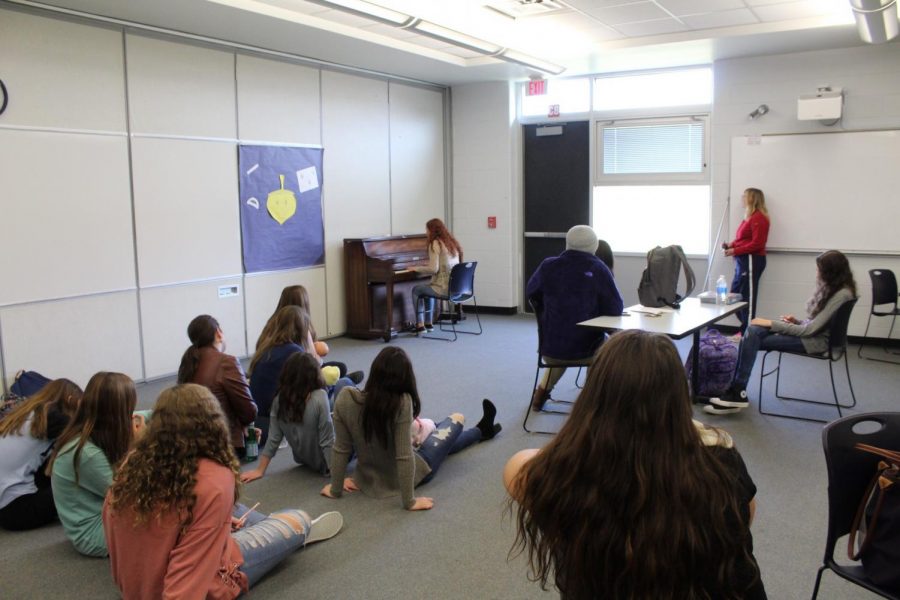 Students who attend Musical Mindful Mondays sit on the floor to listen to their classmates.