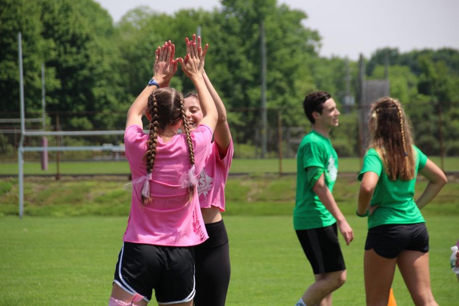 Pink Team captain and senior Izzy Cavazzoni of Wall and junior Erica Sammarco of Colts Neck high five after a victory in soccer. The Pink Team placed third overall in the event.