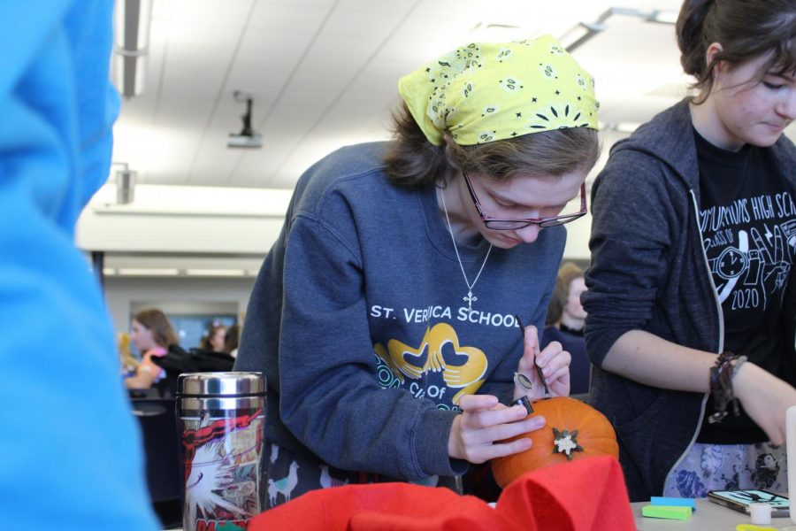 Junior Emily Madeira of Howell draws on one of the Class of 2020s pumpkins for the Pumpkin Decorating competition.