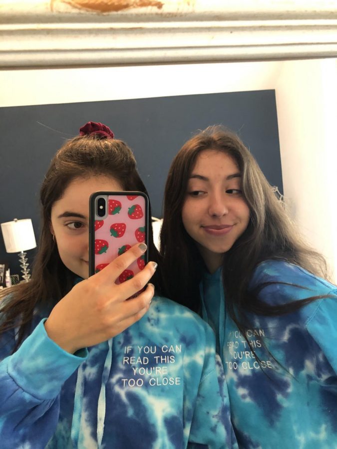 Senior Emma Barofsky, right, poses in her self-designed
sweatshirts with her sister, Julia Barofsky. Profits from
sweatshirt sales were donated to the CDC Foundation.