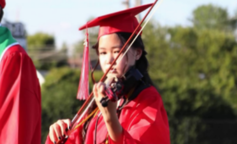 Lily Costa performs on violin at her middle school graduation.