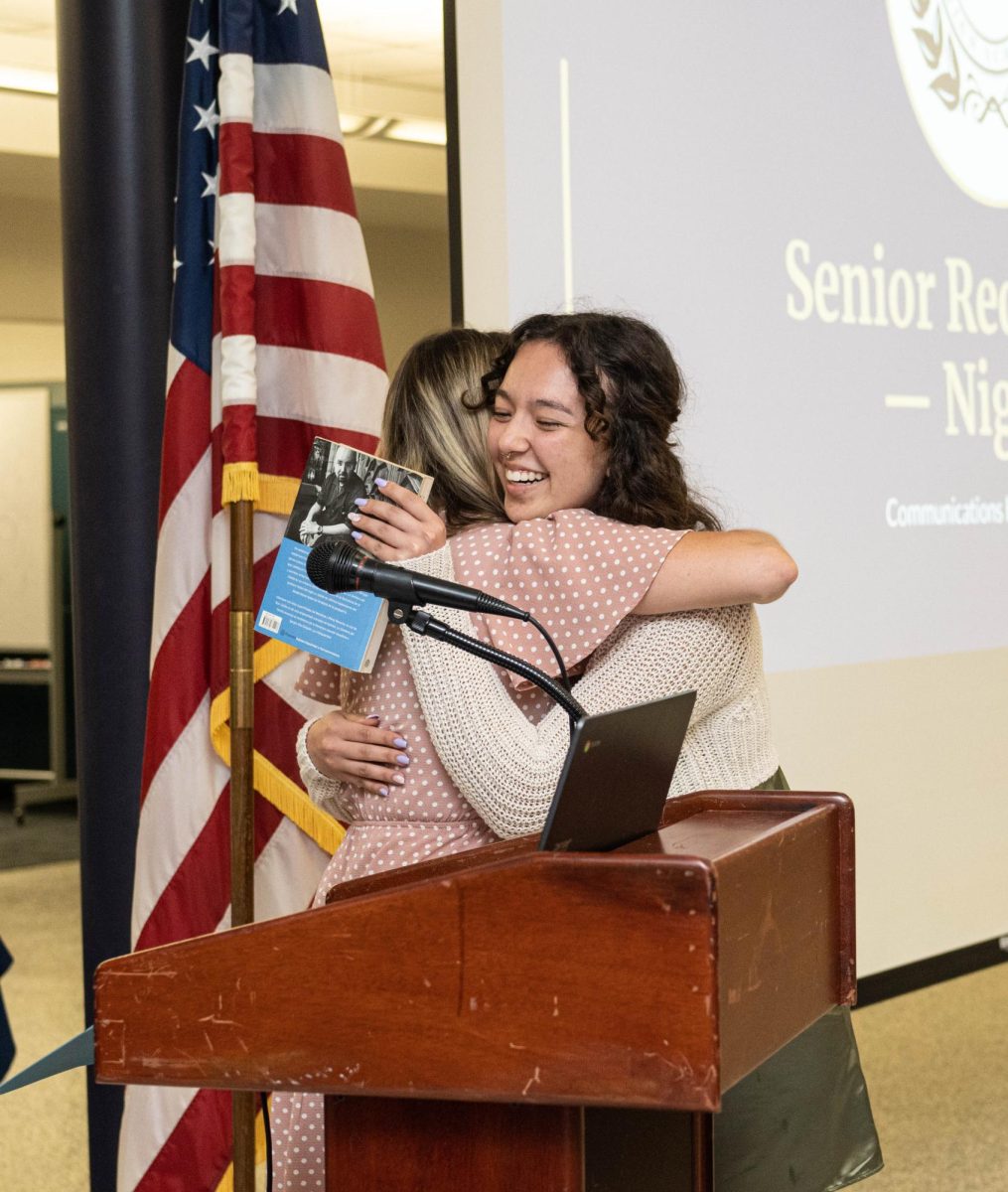 Senior Ayumi Sykes receives award at senior award night from Spanish teacher, Courtney Van Arsdale.